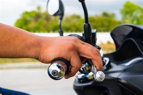 imagem da mão do piloto na alavanca do freio da motocicleta