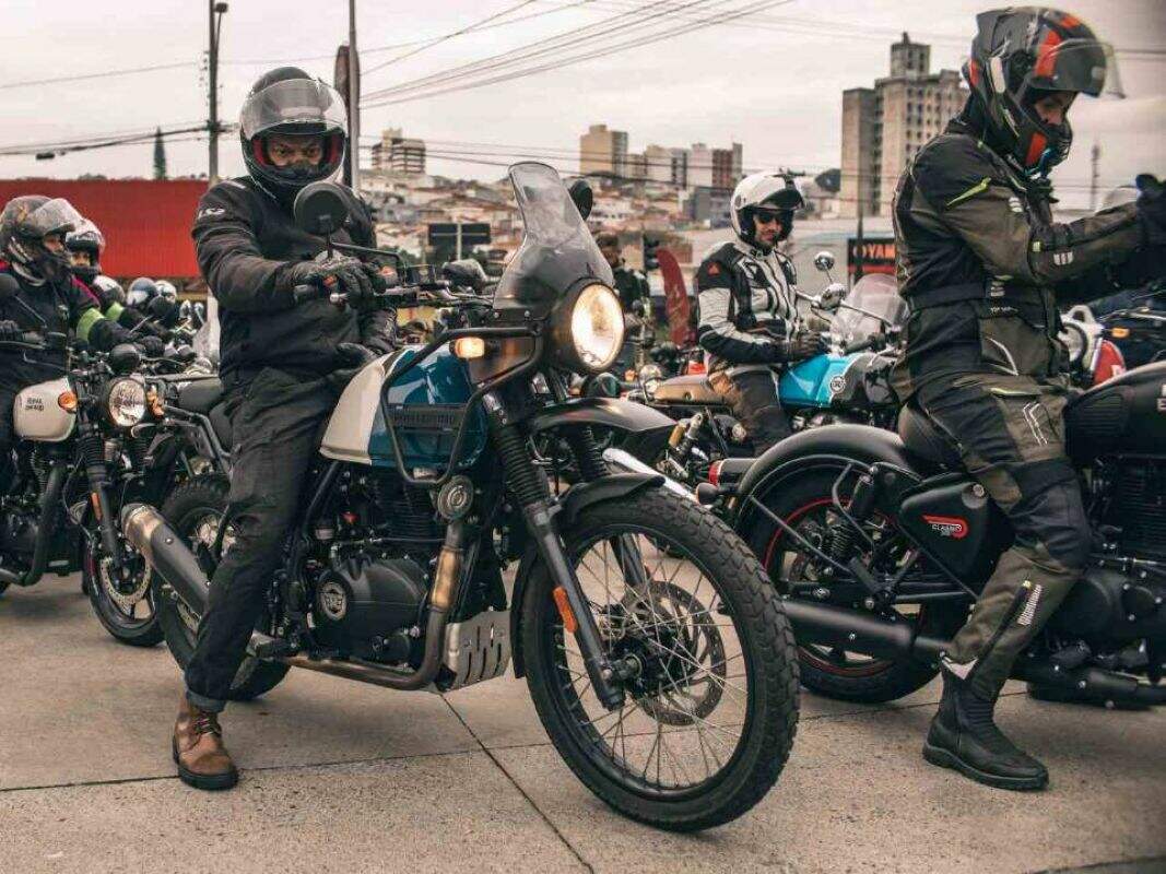 Piloto conduzindo uma motocicleta Royal Enfield Himalayan 450 com o logotipo da marca e selo da indicação ao Prêmio Reclame Aqui 2026.