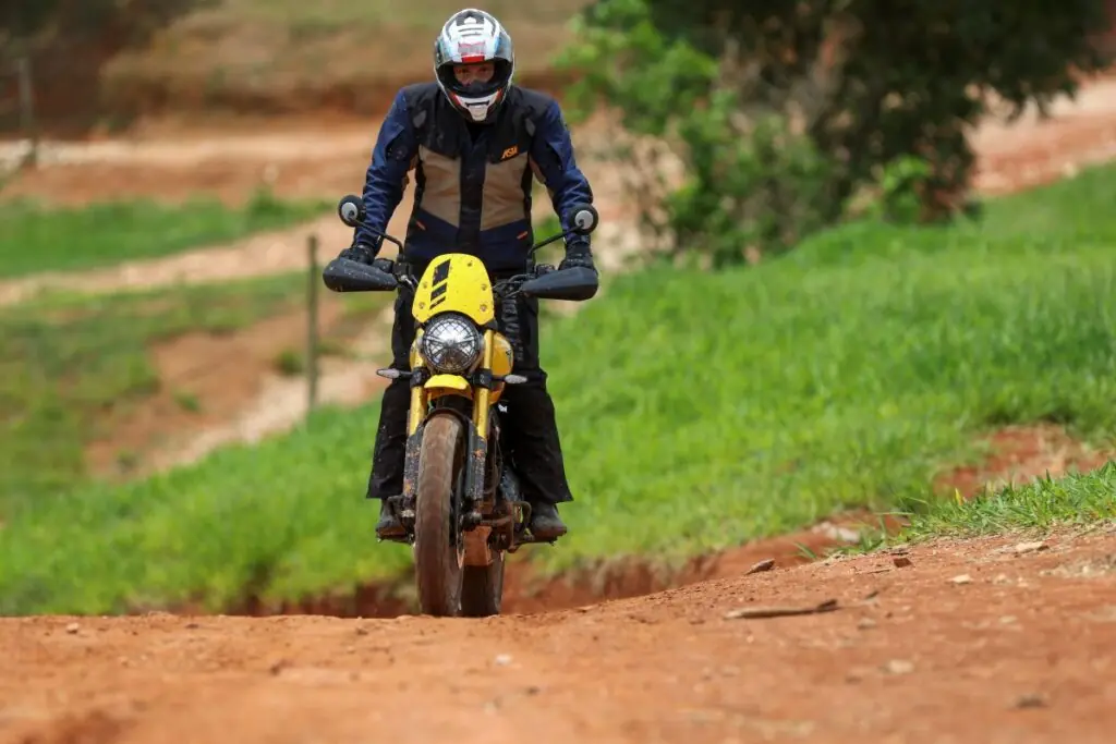 imagem do piloto em ação na terra com a Triumph Scrambler 400 XC